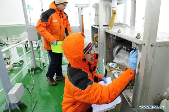 Zhang Miming (R) and Xiao Zhenglin, members of Chinese Antarctic exploration team, record the data of air samples on the icebreaker Xuelong, or Snow Dragon, in Antarctica, Jan. 5, 2014.. (Xinhua/Zhang Jiansong) 