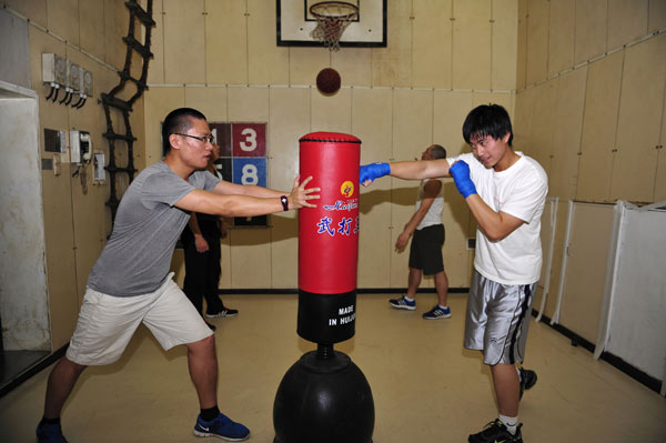 Crew members onboard the Chinese icebreaker Xuelong, which is trapped in Antarctica, practice boxing on Sunday. Wednesday's weather conditions may help the ship break out of frozen floes. ZHANG JIANSONG / XINHUA
