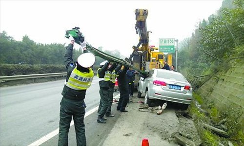 Traffic police attempt to remove the guardrail from the driver's side of the vehicle January 5. Photo: Chongqing Morning Post