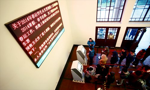 Students wait in line to pick up railway tickets at Tongji University in Yangpu district Thursday. Shanghai's railway bureau has set up 25 ticket machines at eight of the city's universities to make buying tickets more convenient for students. Photo: Yang Hui/GT