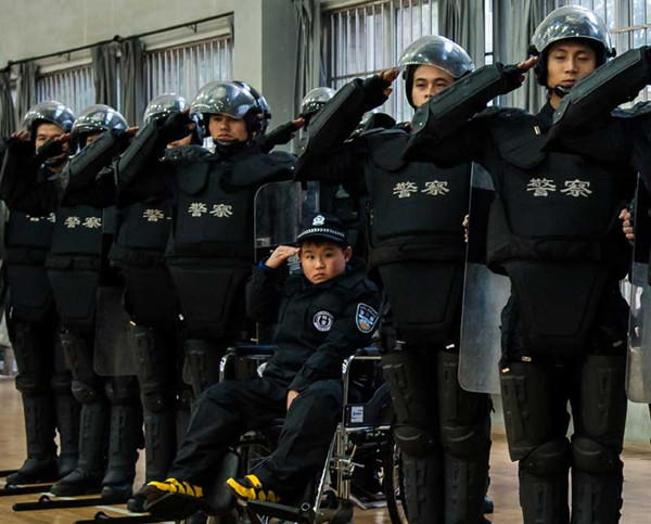 Junyi, 9, is part of the swearing-in ceremony for the Xinyu Public Security Bureau, East China's Jiangxi province, on Jan. 11, 2014. [Photo by Zhang Min/Asianewsphoto]