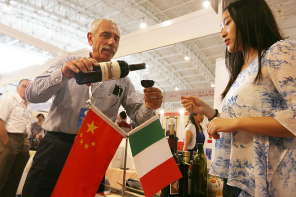 An employee of an Italian winemaker serves a visitor at a light industry and consumer goods exposition in Beijing. China-Italy trade rose 3.9 percent to $43.33 billion in 2013, according to the General Administration of Customs. LEI KESI / FOR CHINA DAILY