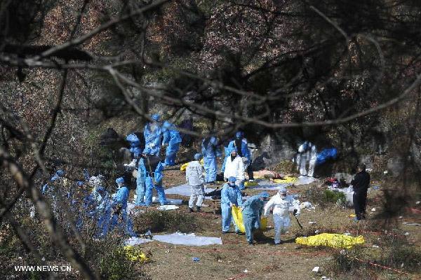 Police officers carry the bodies of the victims at the blast scene in Laoshan Village, Kaili City in southwest China's Guizhou Province, Jan 14, 2014. Eight suspects were detained as the death toll from a southwest China village blast rose to 15. (Xinhua/Ou Dongqu)