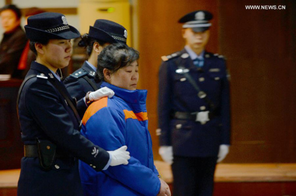 Zhang Shuxia (2nd R), an obstetrician in northwest China's Shaanxi Province, who is involved in a baby trafficking scandal, is escorted off the Weinan Intermediate People's Court in Weinan, Shaanxi Province, Jan 14, 2014. (Xinhua/Li Yibo)