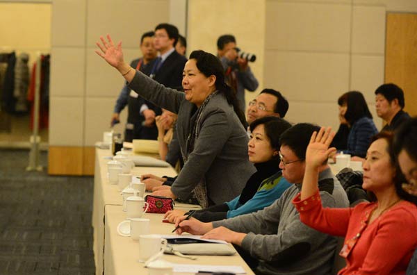 Sun Meiping, a political adviser, stands and raises her hand to ask a question at a meeting on social management on Saturday during a plenary session of the Beijing Municipal Committee of the Chinese People's Political Consultative Conference. Photo by Feng Yongbin / China Daily