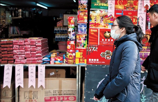 A woman wearing a mask walks past a fireworks stall on Xiangyang Road S. Monday. The citys air was heavily polluted yesterday due to pollutants brought by a cold front from the north. (Yang Yi) 