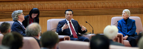 Premier Li Keqiang chats with John Lawson Thornton, chairman of the board of the Brookings Institution (left), Canadian educationist Isabel Crook and other foreign experts at the Great Hall of the People in Beijing on Tuesday. FENG YONGBIN /CHINA DAILY 