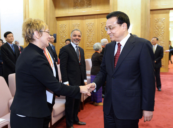 Chinese Premier Li Keqiang shakes hands with a foreign expert at a seminar held in Great Hall of the People with over 70 foreigners working in China, Jan 21, 2014. [Photo/Xinhua]