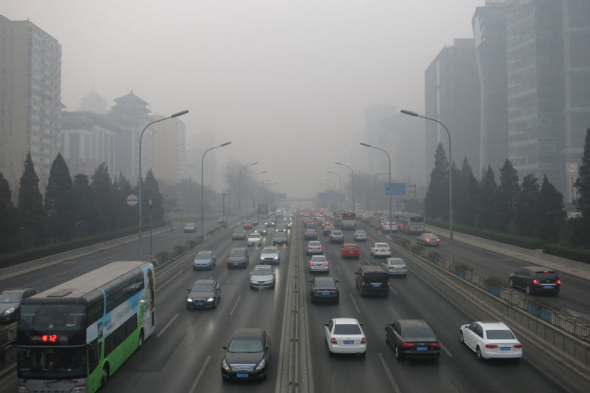 Cars are passing the main road with their lights on in case of accidents as Beijing is once again hit by severe smog today. Data reads the AQI (Air Quality Index) reaching 493, which indicates dangerous air pollution. [Photo: CRIGENGLISH.com/ William Wang]