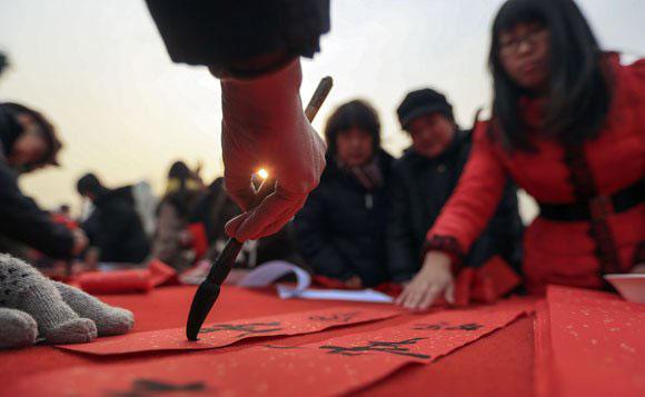 Calligraphers give Spring Festival scrolls to citizens at Dongyue Temple, Beijing.