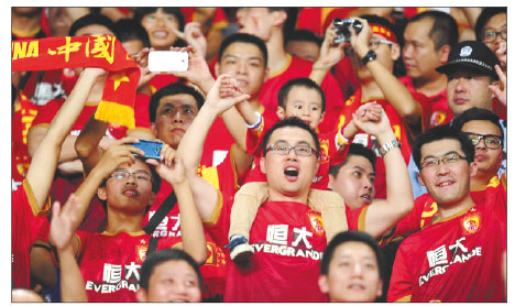 Fans of Guangzhou Evergrande cheer for their team during a match in Guangzhou, Guangdong province, on Nov 9. The team clinched their first AFC Champions title with a 1-1 draw with FC Seoul. WU JUN / FOR CHINA DAILY 