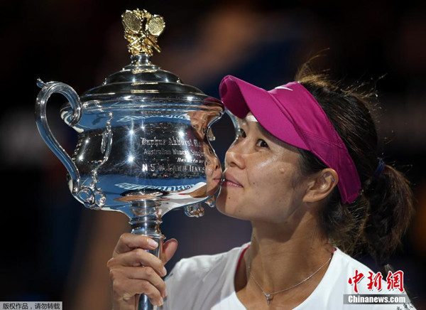 Li Na kisses The Daphne Akhurst Memorial Cup after defeating Dominika Cibulkova of Slovakia in their women's singles final match at the Australian Open 2014 tennis tournament in Melbourne January 25, 2014. [Photo/Agencies]