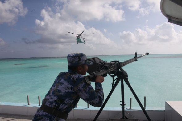 A soldier of the People's Liberation Army navy stands guard during a drill to test the defense of the Nansha Islands. Battleships from the PLA navy's South Sea Fleet are undergoing a long-distance training mission while patrolling the Xisha and Nansha islands. Gao Yi / For China Daily