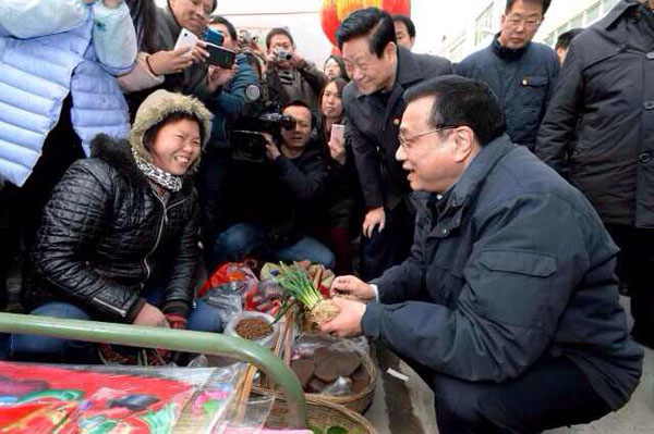 Chinese Premier Li Keqiang talks with vendors and buyers at a fair in Ankang city, Northwest China's Shaanxi province, Jan 27, 2014. [Photo/Xinhua]