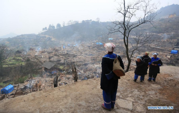 A villager looks at ruins of burnt houses in Baojing Dong Village of Zhenyuan County, southwest China's Guizhou Province, Jan 26, 2014. (Xinhua/Li Lin)
