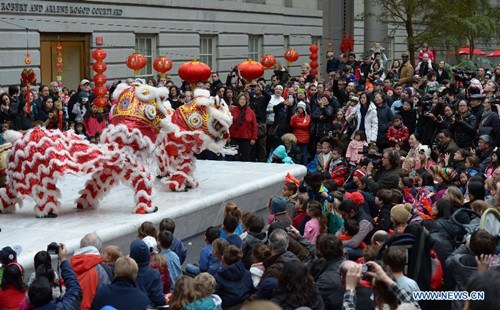 People watch lion dancing during an event celebrating the upcoming Chinese Lunar New Year at Smithsonian American Art Museum, Washington D.C., the United States, Jan 25, 2014. (Xinhua/Yin Bogu)