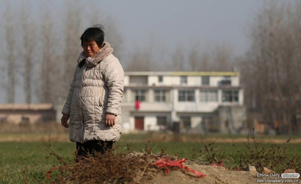 Gao Hongtao, a teenager uremic young man, commits suicide to save his elder brother, who also has the disease. His mother was at the grave. [photo / China Daily]