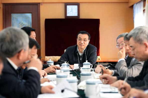 Chinese Premier Li Keqiang (C) presides over a meeting on the train during his tour to deprived regions in Shangluo City and Ankang City, northwest China's Shaanxi Province, Jan 26, 2014. (Xinhua/Li Tao)