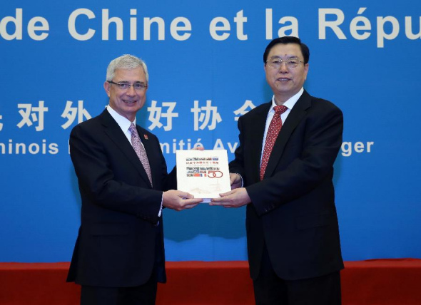 Zhang Dejiang (R) gives a picture album as gift to Claude Bartolone (L), president of the French National Assembly, at a reception celebrating the 50th anniversary of the establishment of diplomatic ties between China and France, in Beijing, Jan 27, 2014. (Xinhua/Liu Weibing)