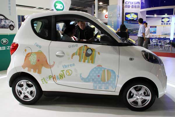 Customers examine an electric car at an exhibition in Beijing on Saturday. The government plans to have at least 10,000 new-energy vehicles sold between 2013 and 2015 in each of the country's megacities, according to the guideline for the electric vehicle industry. WU CHANGQING / FOR CHINA DAILY