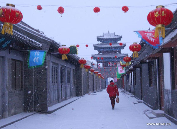 A citizen walks in snow in Penglai City, east China's Shandong Province, Feb. 4, 2014. A snowfall hit the city on the day of Lichun, literally meaning the beginning of the spring according to the traditional Chinese calendar, which falls on Feb. 4 this year. (Xinhua/Yu Liangyi)