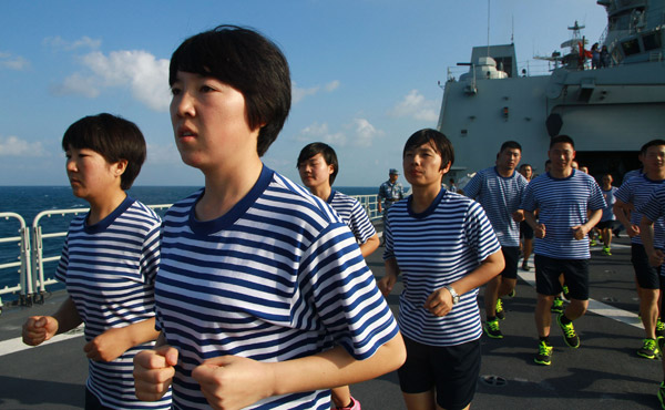 Yong Ronglan (second from left), a sailor from the Xibe ethnic group, takes part in physical training on the Changbaishan, an amphibian landing craft of the Chinese navy. Gan Jun / for China Daily