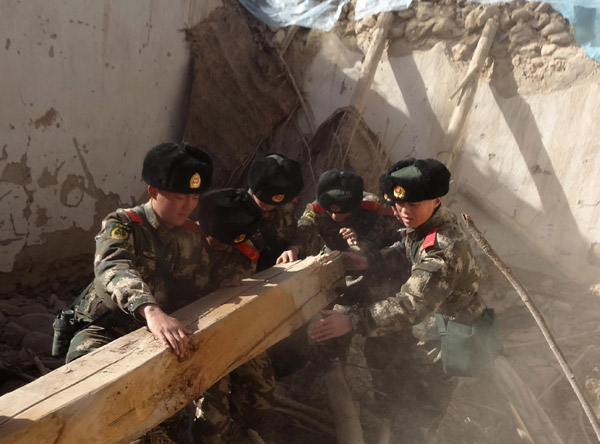Soldiers clear the rubble of a house that collapsed on Wednesday in the magnitude-7.3 earthquake that hit Yutian county, Xinjiang Uygur autonomous region, on Thursday. ZHOU MI / FOR CHINA DAILY 