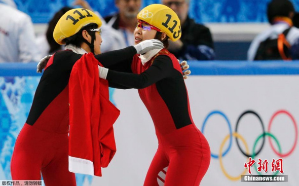 Winner China's Zhou Yang (R) embraces her compatriot China's Li Jianrou after the women's 1,500 metres short track speed skating finals race at the Iceberg Skating Palace at the Sochi 2014 Winter Olympic Games February 15, 2014. [Photo: Agencies]
