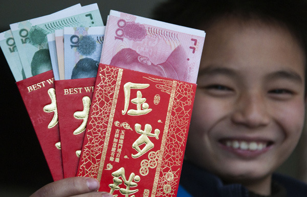 A boy shows the red envelopes he received during Spring Festival this year in Shaoyang, Hunan province. Lyu Jianshe / for China Daily