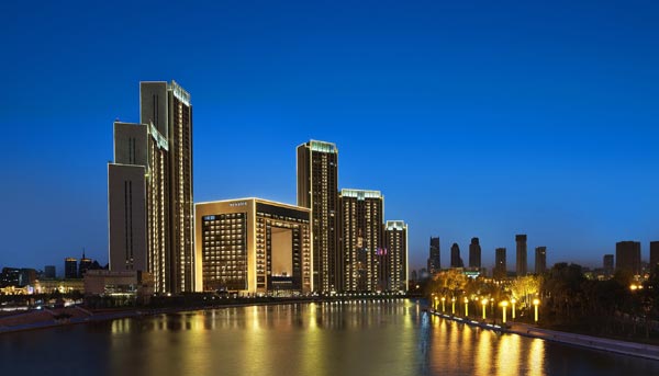 The St. Regis Tianjin takes the shape of a hollowed cube, overlooking the Haihe River and emphasizing the 
