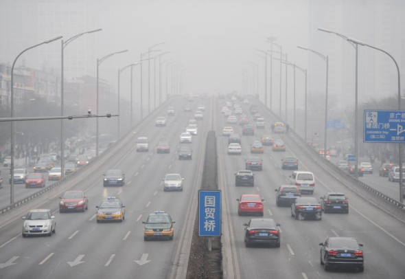 Vehicles run on smog-shrouded road in Beijing, capital of China, Feb 20, 2014. Beijing on Thursday issued a yellow alert for air pollution in the next three days.  (Xinhua/Luo Xiaoguang) 