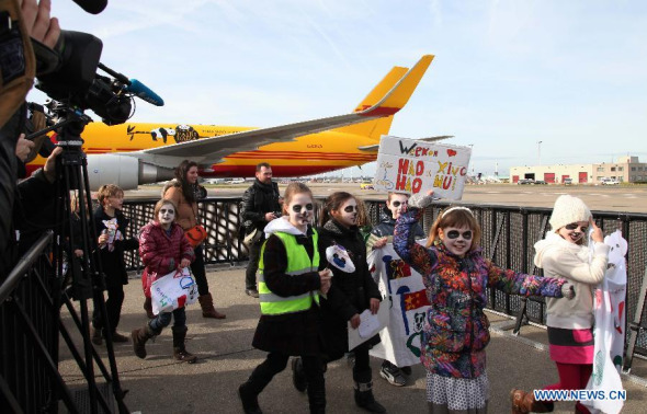Children welcome giant pandas Xing Hui and Hao Hao at the Brussels National Airport in the capital of Belgium on Feb 23, 2014. The pair of giant pandas, Xing Hui, the male, and Hao Hao, the female, arrived in Belgium Sunday, on lease from their breeding center in southwest China's Sichuan province. They are both four years old and will stay in Belgium for the next 15 years. (Xinhua/Sun Wen)
