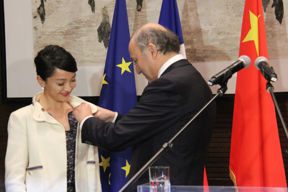 Chinese actress Zhou Xun (L) receives the Chevalier medal in the Order of Arts and Letters from French French Foreign Minister Laurent Fabius (R) in Beijing on Friday Feb. 21, 2014. [Photo: CRIENGLISH.com/Zhao Pingping]