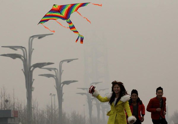 Tourists from Sichuan province brave heavy smog on Monday to fly a kite near the National Stadium. The haze is likely to continue in Beijing this week. Air pollution is likely to be hot topic during the upcoming two sessions in Beijing next month. Zhang Wei / China Daily