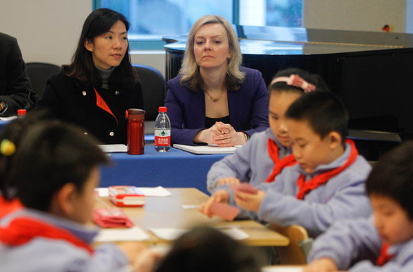 Elizabeth Truss (center), British under secretary of state with responsibility for education and childcare, attends a math class for third-graders at a primary school in Shanghai on Monday. GAO ERQIANG / CHINA DAILY