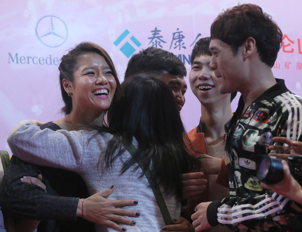 Tennis star Li Na is hugged by fans on Saturday during a celebration of her Australian Open victory and launch of a new book in Beijing. Li said she is looking for partners to work with to build a school that combines academic education and tennis training, a different structure from the current State-run athlete training system. Zou Hong / China Daily 