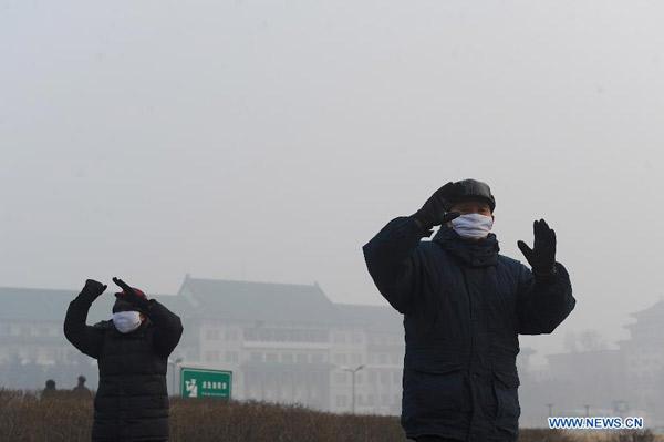 Citizens wearing masks do exercises amid smog in Changchun, capital of northeast China's Jilin province, Feb 25, 2014. Many cities maintained alert for air pollution on Feb 25 since the fog and smog choked northern China days ago. (Xinhua/Lin Hong)