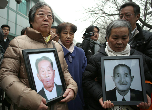 Relatives of deceased Chinese forced laborers, accompanied by lawyer Kang Jian (center, in blue coat), attend Beijing No 1 Intermediate Peoples Court on Wednesday to sue two Japanese companies over forced labor during World War II. The lawsuit seeks printed apologies to be carried in Chinese and Japanese newspapers as well as compensation from the Japanese companies. WANG JING / CHINA DAILY 