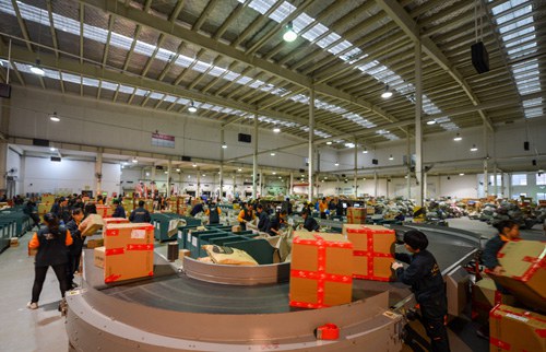 ONLINE SHOPPING SPREE: Workers process packages in a sorting center in Changsha of central China's Hunan province on November 12, 2013. Postal EMS services have developed fairly fast in China in recent years (XINHUA)