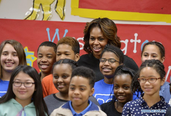 US First Lady Michelle Obama poses for photos with students at Yu Ying Public Charter School, a chinese-immersion, International Baccalaureate, elementary school, before traveling to China, in Washington D.C., the United States, on March 4, 2014. The First Lady will visit China later in March. (Xinhua/Yin Bogu)