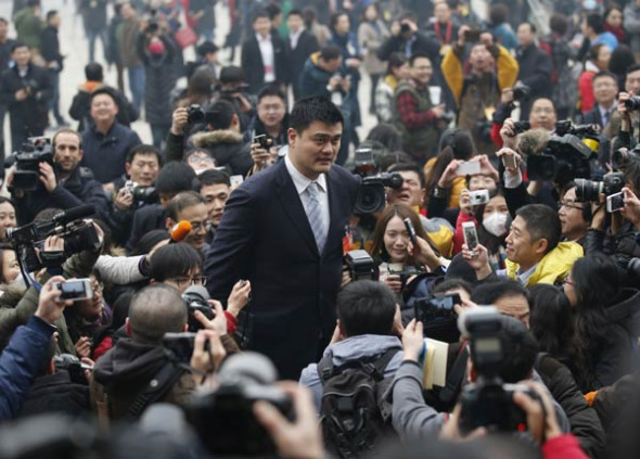 Former NBA basketball player Yao Ming (C), who is a delegate of the Chinese People's Political Consultative Conference (CPPCC), is surrounded by media ahead of the opening of CPPCC outside the Great Hall of the People in Beijing, March 3, 2014. [Photo source: China Daily]