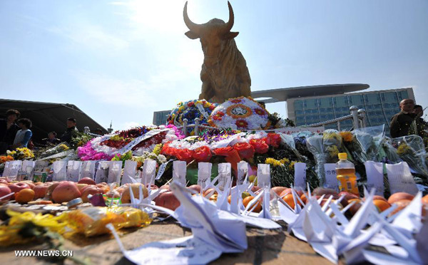 Sacrifices, flowers and origami cranes are presented to mourn the victims of a terrorist attack at the square of Kunming Railway Station in Kunming, capital of southwest China's Yunnan Province, March 7, 2014, seven days after the bloodbath. A group of knife-wielding attackers slashed frantically at crowds at Kunming railway station on March 1, killing 29 innocent lives and injured 143 others. (Xinhua/Lin Yiguang) 