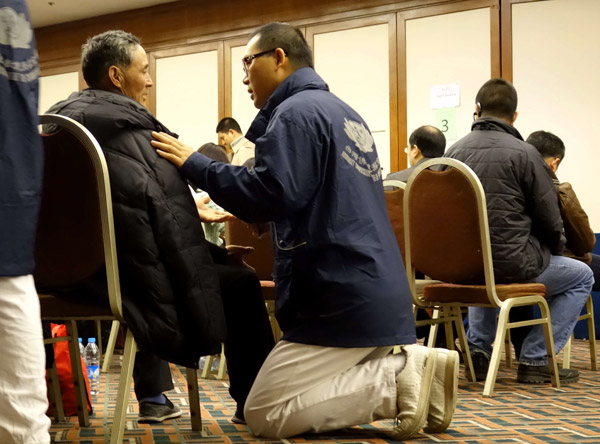A volunteer from Taiwan's Tzu Chi Foundation comforts a relative of one passenger aboard the missing Malaysia Airlines flight at the Lido Hotel in Beijing on Monday. The air carrier has arranged for the families to rest at the hotel while waiting for updates. Cai Daizheng / For China Daily 