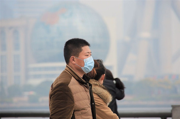A man on the Bund wears a mask Monday, as PM2.5 levels rose to more than double the national standard. (Zhang Suoqing) 