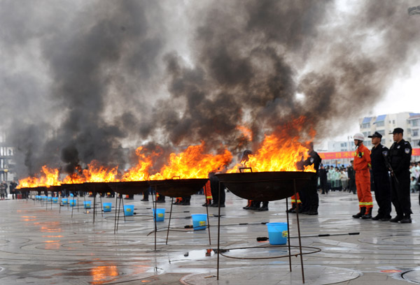 Police in Ningming, Guangxi Zhuang autonomous region, burn 1 metric ton of confiscated narcotics on Monday. The drugs, including heroin, were seized along the China-Vietnam border since the start of 2013. LI BIN / XINHUA 
