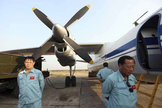 Cabin crew of Vietnam Air Force's AN26 aircraft waits at a base near Tan Son Nhat airport, Hochiminh city before a search operation for the missing Malaysian Airlines Boeing 777 over the seas between Malaysia and Vietnam Tuesday, March 11, 2014.