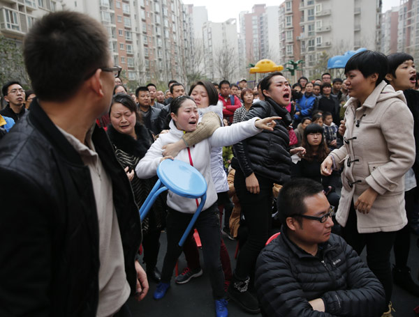 Angry parents come to a private kindergarten in Xian on Tuesday to demand an explanation about drugs they say were given to their children. The local government sent a team to the kindergarten to investigate. [Deng Xiaowei/China Daily]