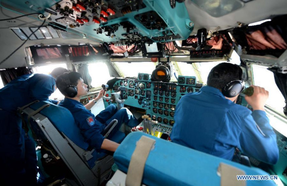Crew members operate on a Chinese Air Force aircraft above sea areas where the missing Malaysia Airlines flight MH370 lost contact, Malaysia, March 12, 2014. Multinational search operation to locate missing Malaysia Airlines flight MH370 has been expanded to two areas with more countries joining in the mission. (Xinhua/Shen Ling)