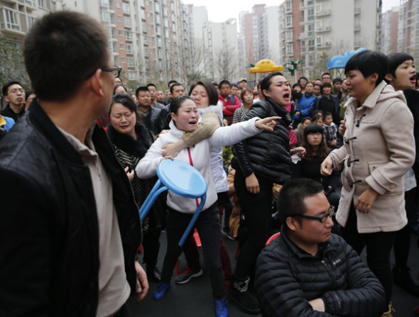Angry parents come to a private kindergarten in Xi'an on Tuesday to demand an explanation about drugs they say were given to their children. The local government sent a team to the kindergarten to investigate. [Deng Xiaowei/China Daily]
