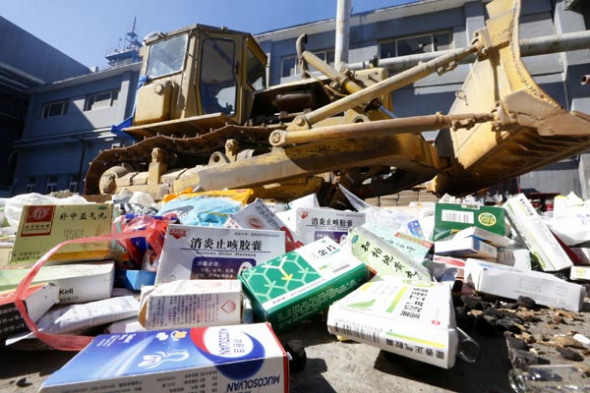 Fake and substandard food and medicine being destroyed in Beijing on Friday on the eve of World Consumer Rights Day. In 2013,the China Consumers' Association handled 550,000 complaints from consumers and resolved 93 percent of them. [Cao Boyuan / China Daily]